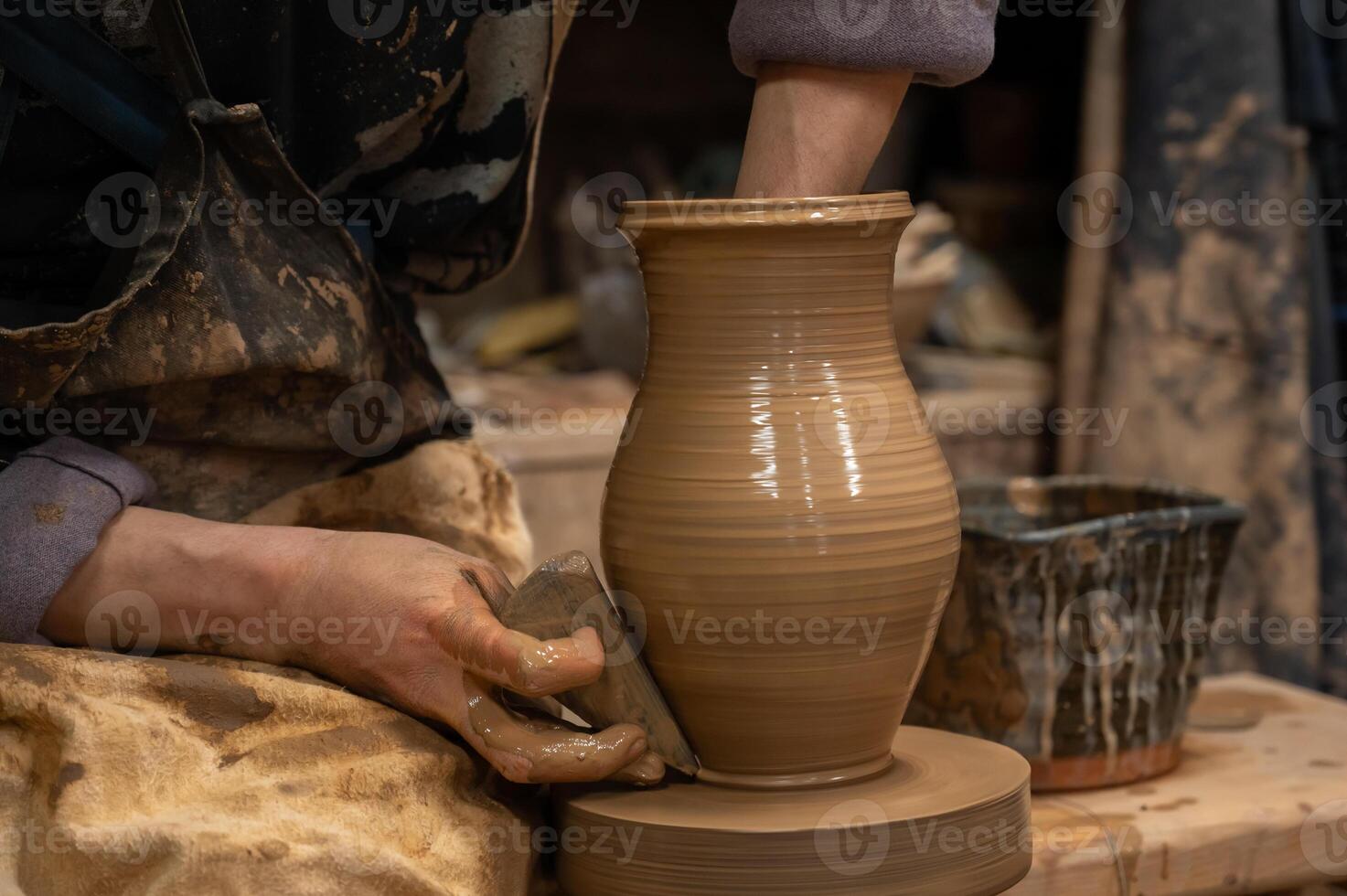 a person is making a vase on a potter's wheel photo