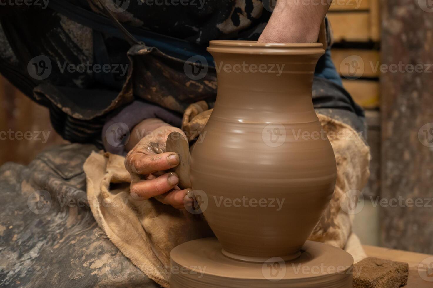 a man is making a pottery vase on a pottery wheel photo