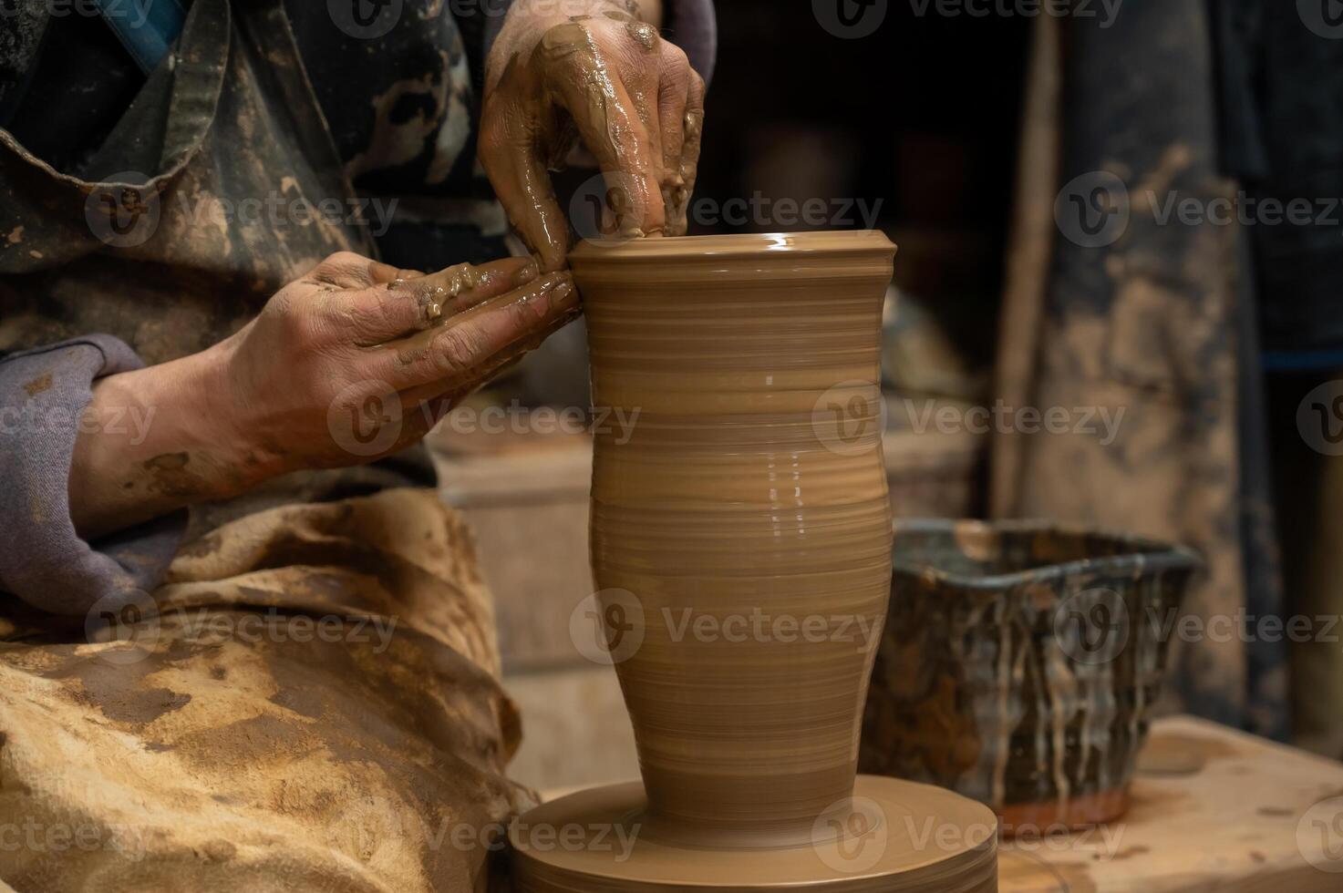 a potter is making a vase on a potter wheel photo