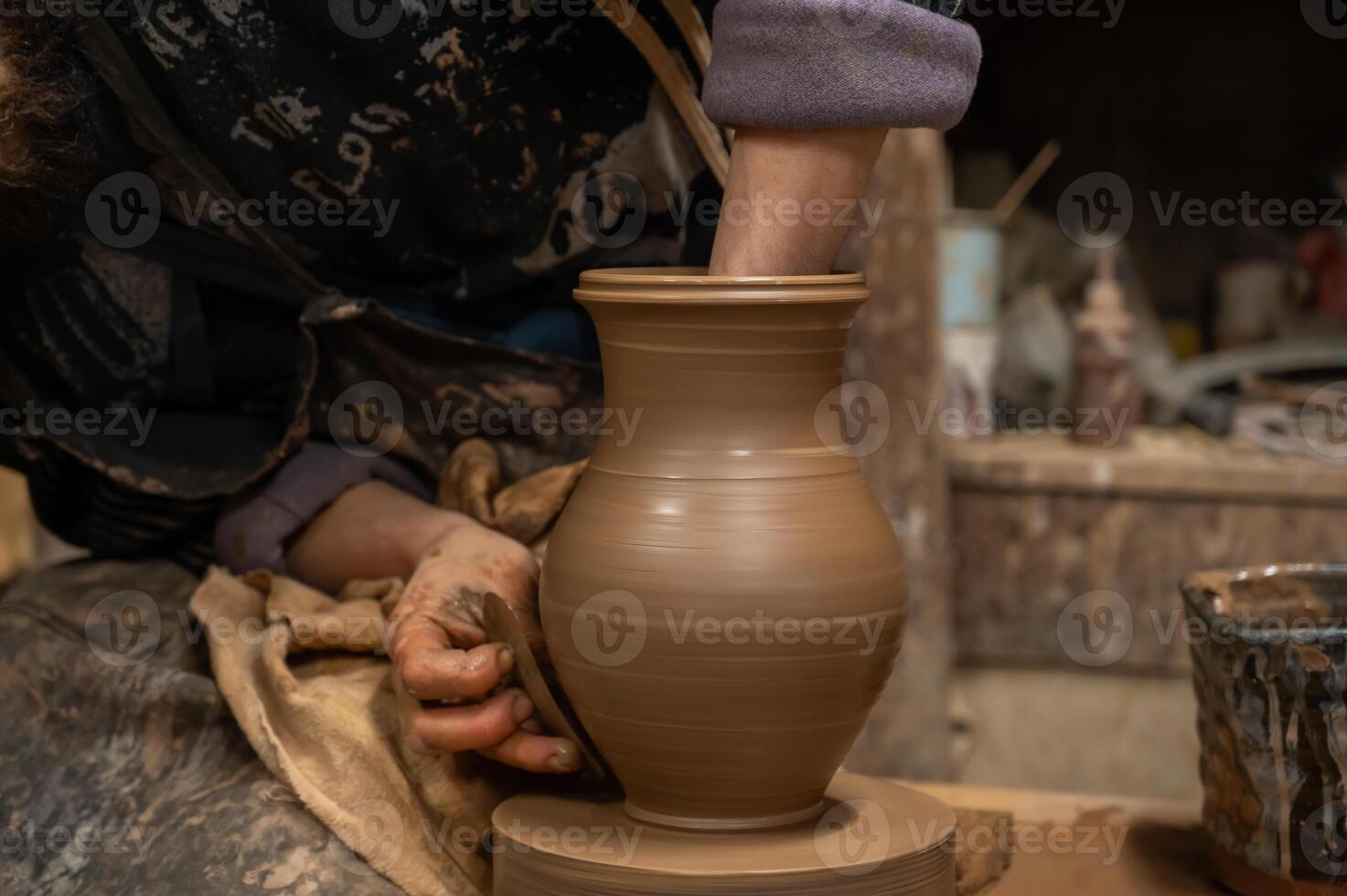 a person is making a pottery vase on a pottery wheel photo