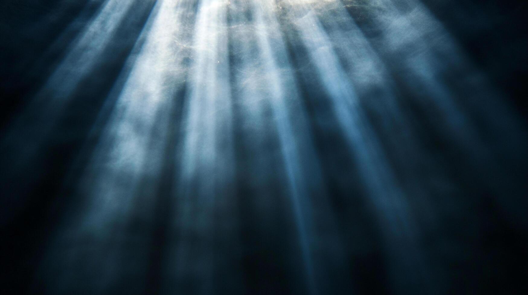 Sunlight streams through a dark, possibly underwater environment, creating ethereal beams and contrasting light and shadow. photo