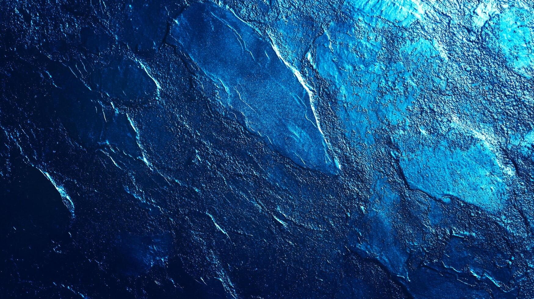 Dramatic blue rock face with textured, fractured surfaces. An abstract representation of nature's power in deep blue hues. photo