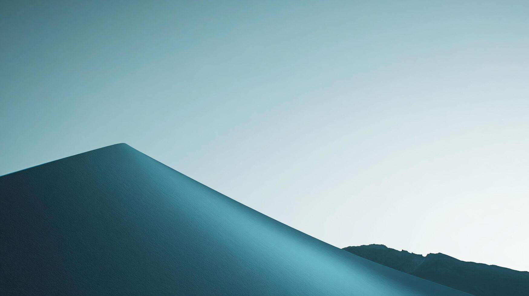 Minimalist landscape showing a sand dune gently sloping under a clear sky at sunrise, creating a serene and peaceful atmosphere photo