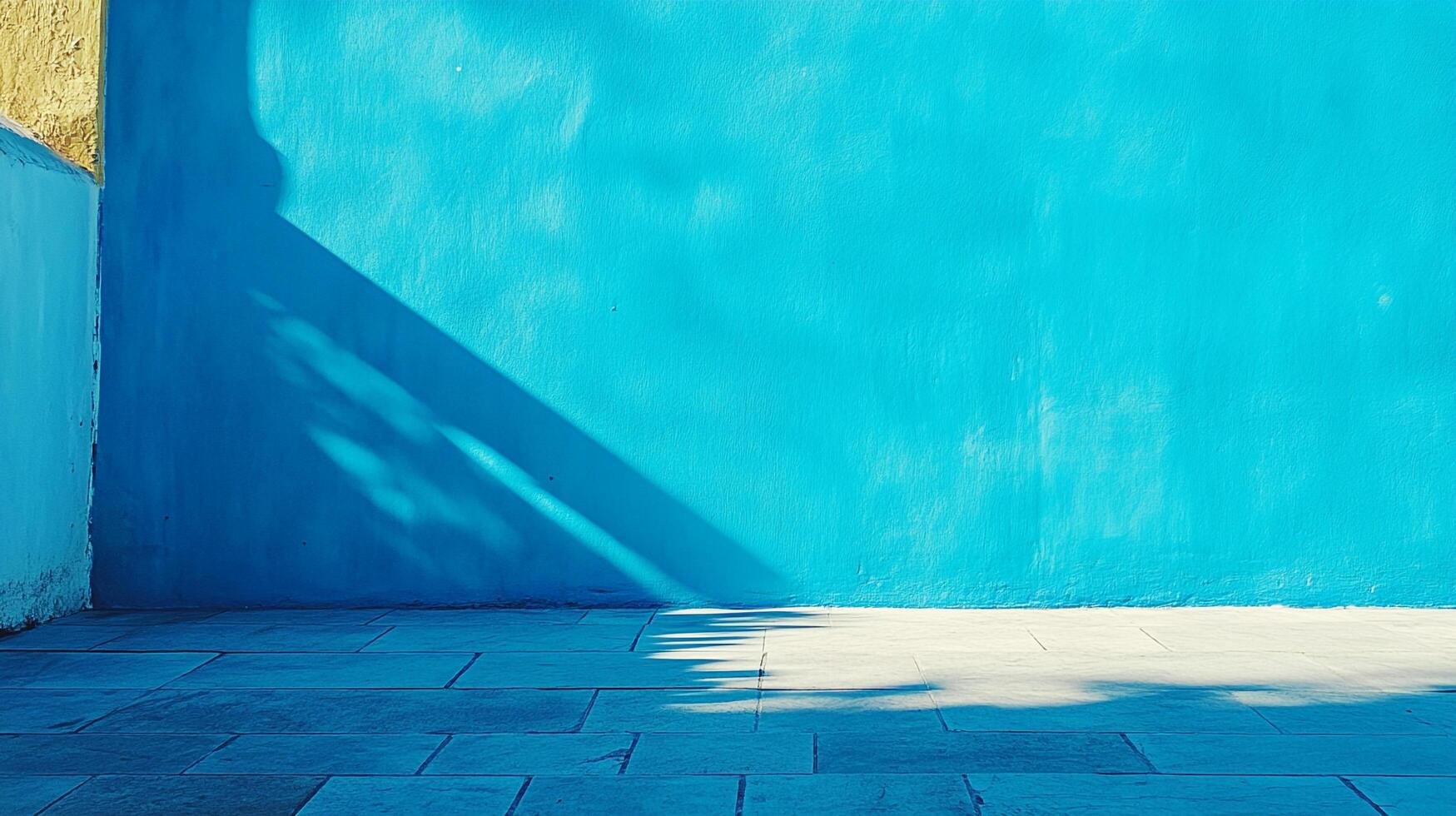 A vibrant turquoise wall basks in sunlight, casting shadows on the stone floor, creating a captivating play of color and light. photo
