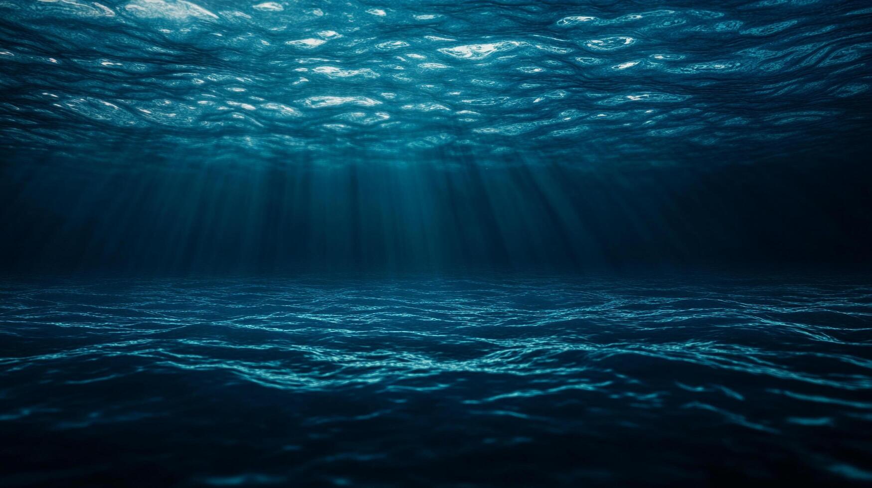Underwater rays of light pierce the depths of the dark sea, creating an ethereal atmosphere under the rippling surface. photo