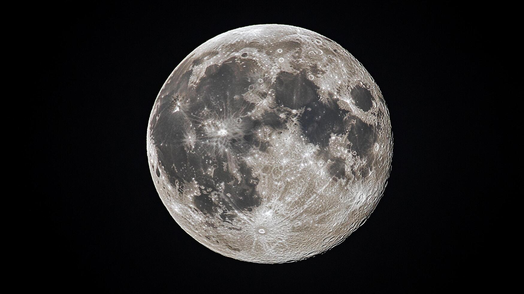 Detailed view of a full moon in space, showcasing craters and textures. The moon is bright against the black background, revealing lunar details. photo