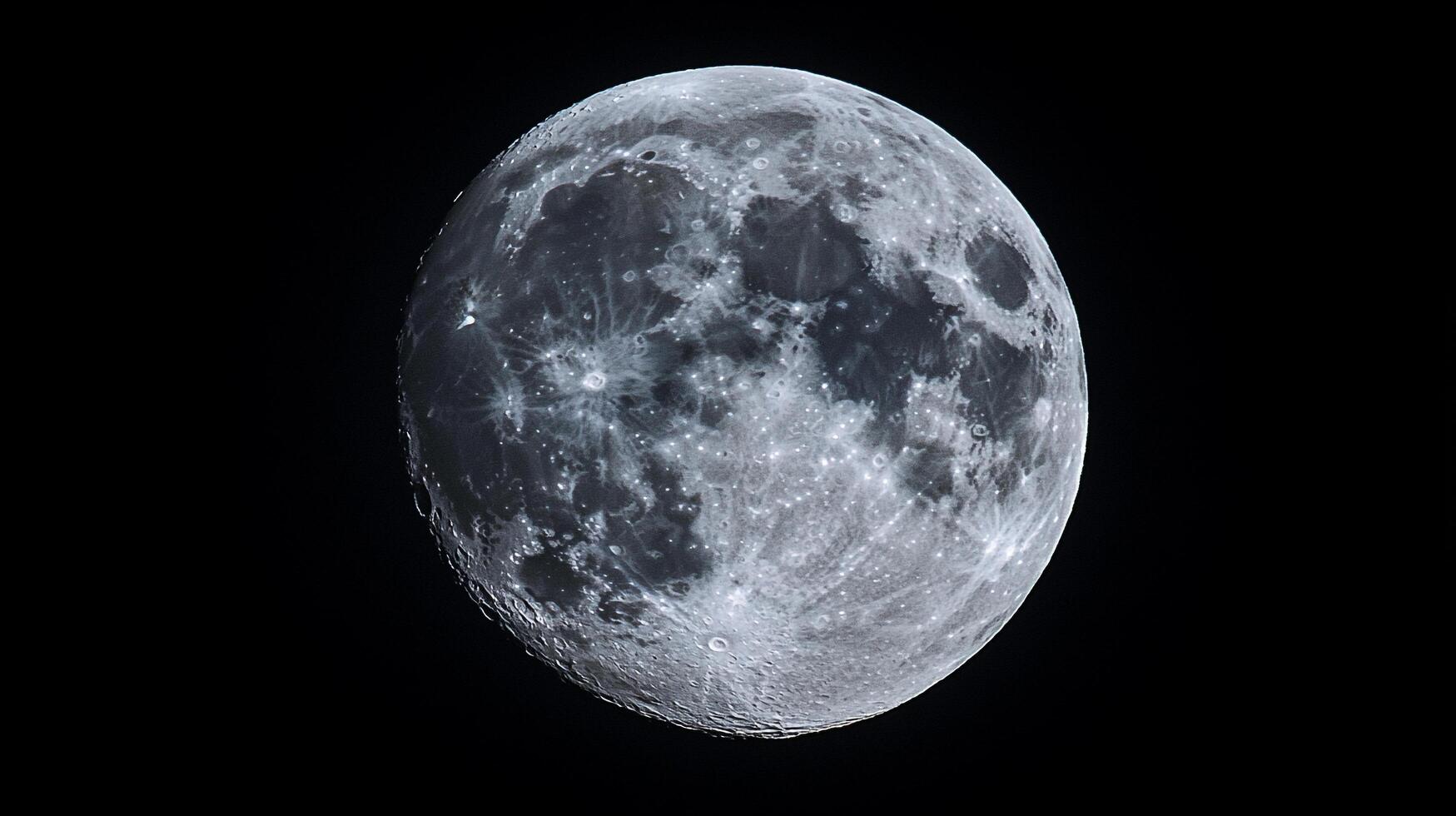 Detailed lunar surface against the dark expanse of space. Craters and textures visible in the Moon's glow against the black background. photo