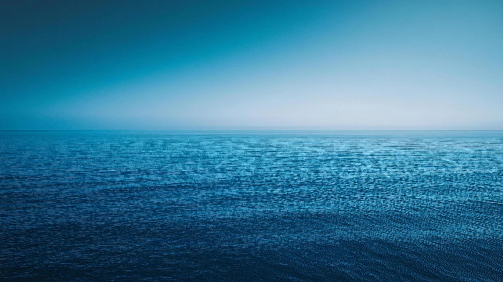 Vast expanse of calm ocean water stretching to the horizon under a gradient blue sky. A scene of tranquility and natural beauty. photo
