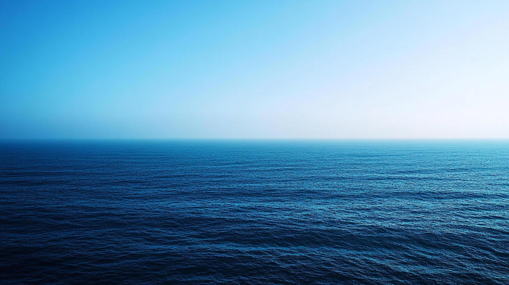 A serene expanse of water meets the sky, transitioning from deep blues to soft, ethereal light. Open water stretches to the horizon. photo
