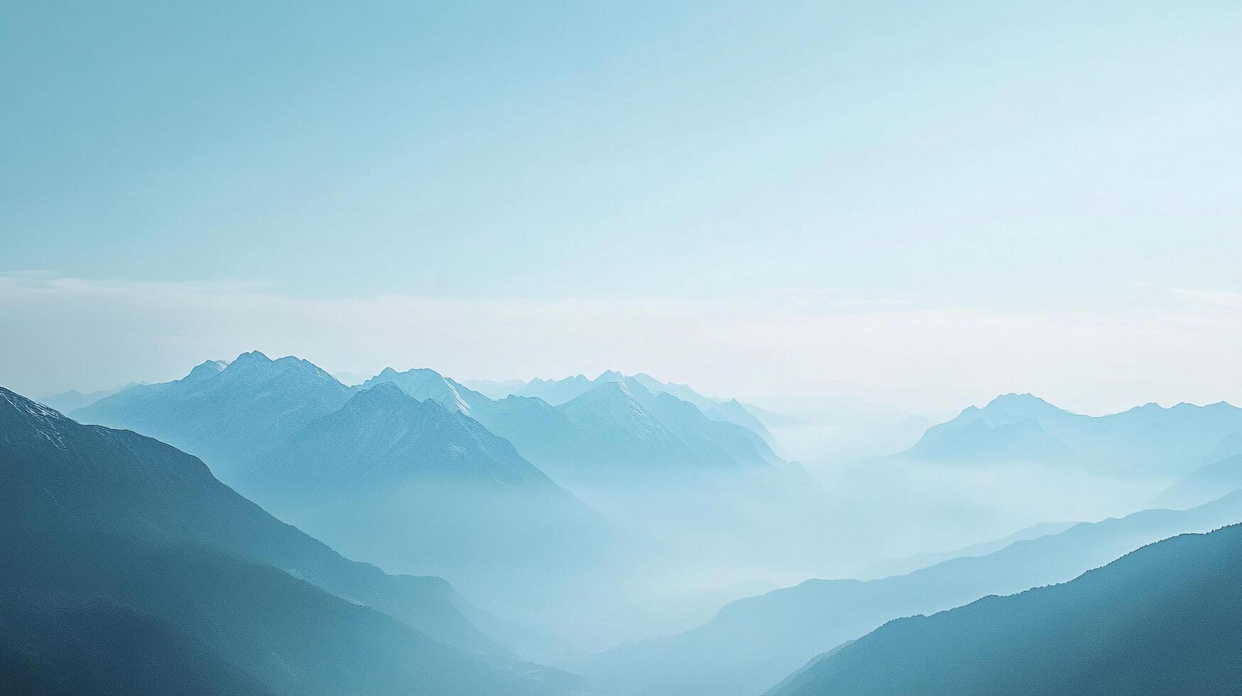 Misty mountain range landscape featuring layers of blue shaded peaks and valleys shrouded in fog under a pale blue sky. Serene vista. photo