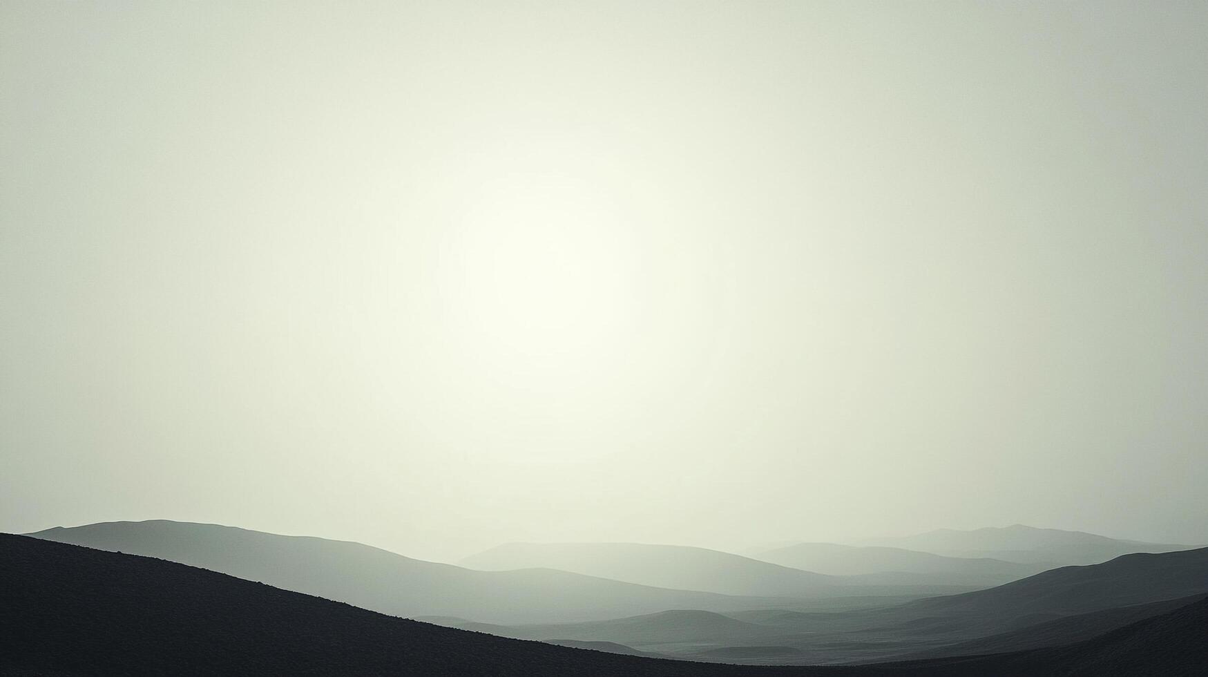 Misty mountain silhouettes fade into a hazy horizon, creating a serene and atmospheric landscape. The light casts a soft glow over the scene. photo