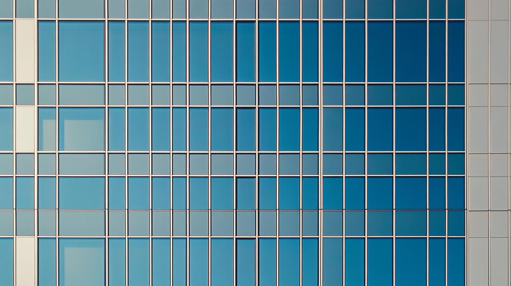Geometric facade with blue glass windows reflecting the sky. Building exterior with clean lines and modern architectural design. photo