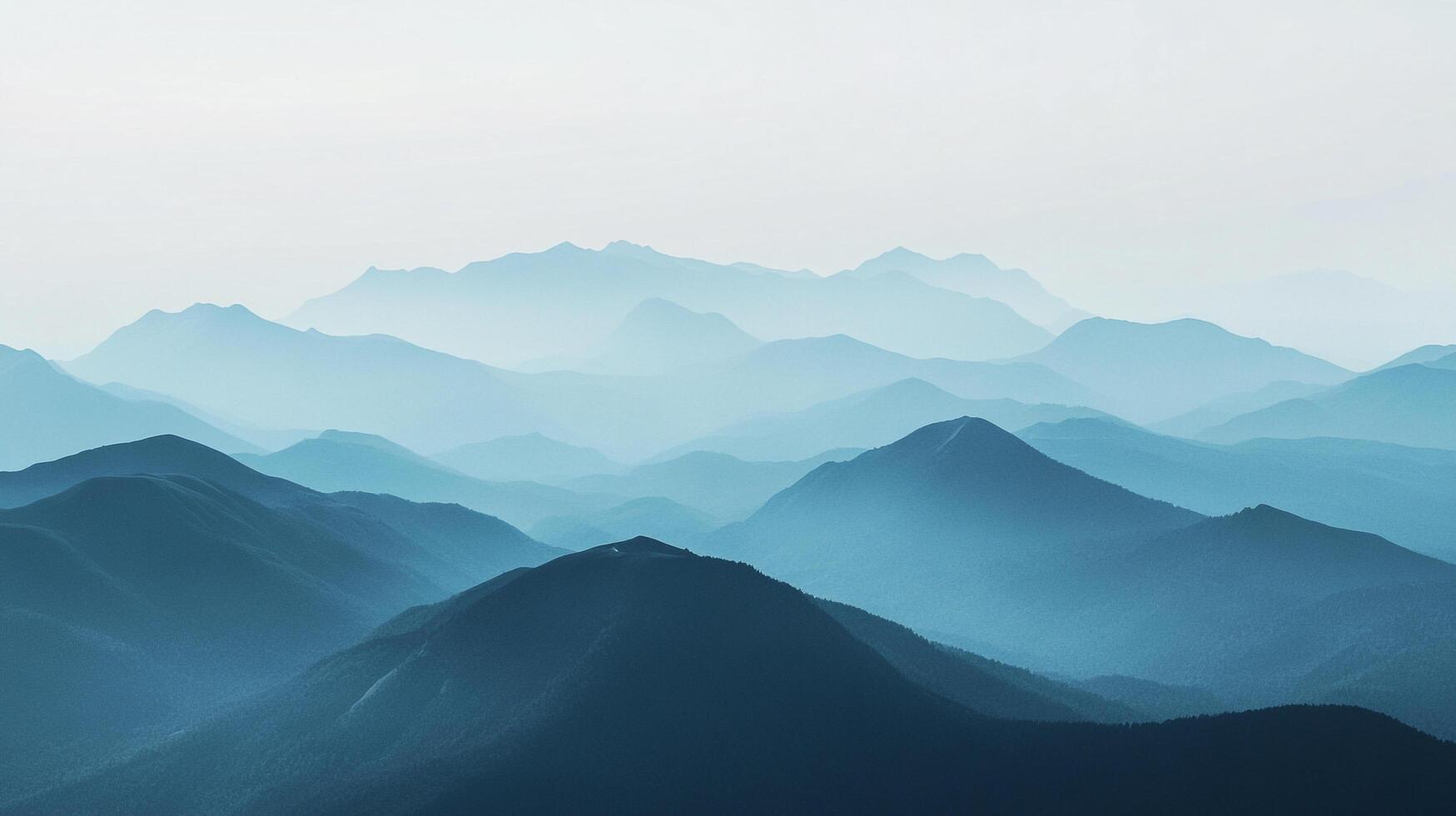 Layers of blue mountains receding into the distance, creating a serene and ethereal landscape, fading into a light sky. photo