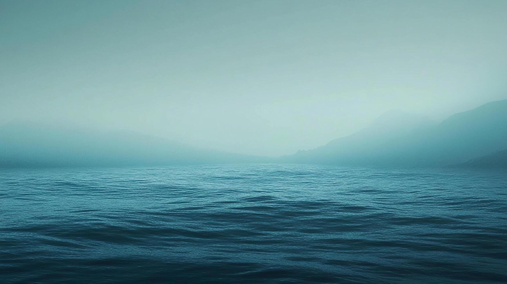 Calm blue waters reflecting the sky, with a hint of misty mountains in the distance, evoking tranquility and peacefulness. photo