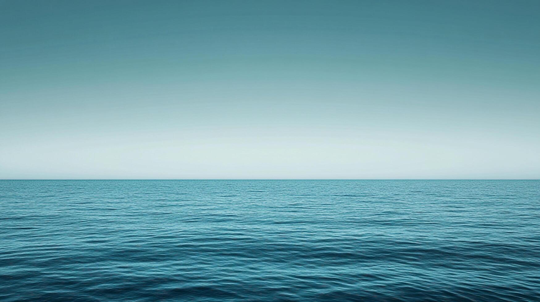 Calm turquoise sea meeting a pale, cloudless sky, creating a serene and vast ocean horizon. Evokes peace and openness in nature. photo