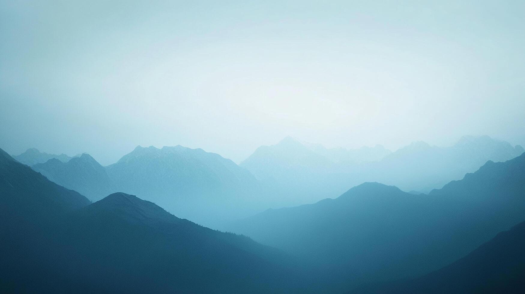 Misty blue mountains fade into the pale horizon, creating a serene and atmospheric landscape scene. Layers of peaks and valleys. photo