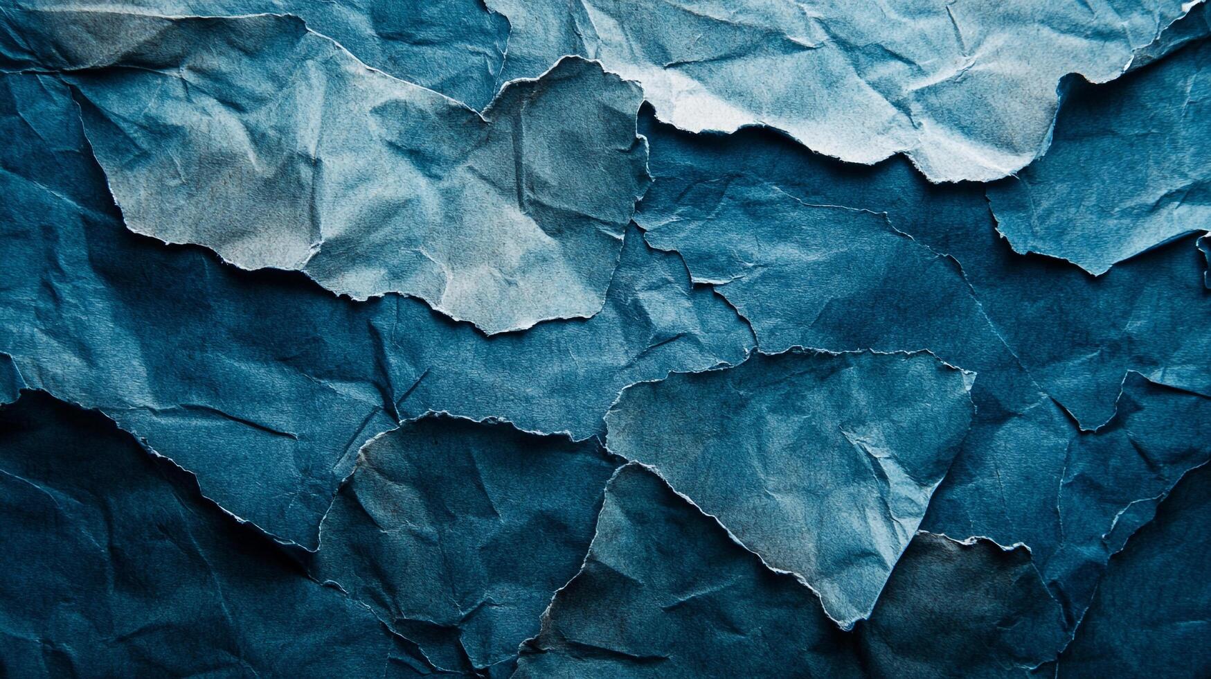 Torn and crumpled blue paper texture featuring rough edges and deep shadows, creating an abstract pattern perfect for artistic backgrounds. photo