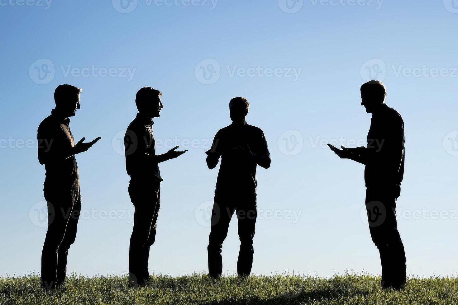 Silhouette of Four People Standing on a Hilltop Against a Blue Sky, Showcasing Teamwork and Communication, Ideal for Business Concepts and Collaboration Visuals, Representing Unity and Agreement photo