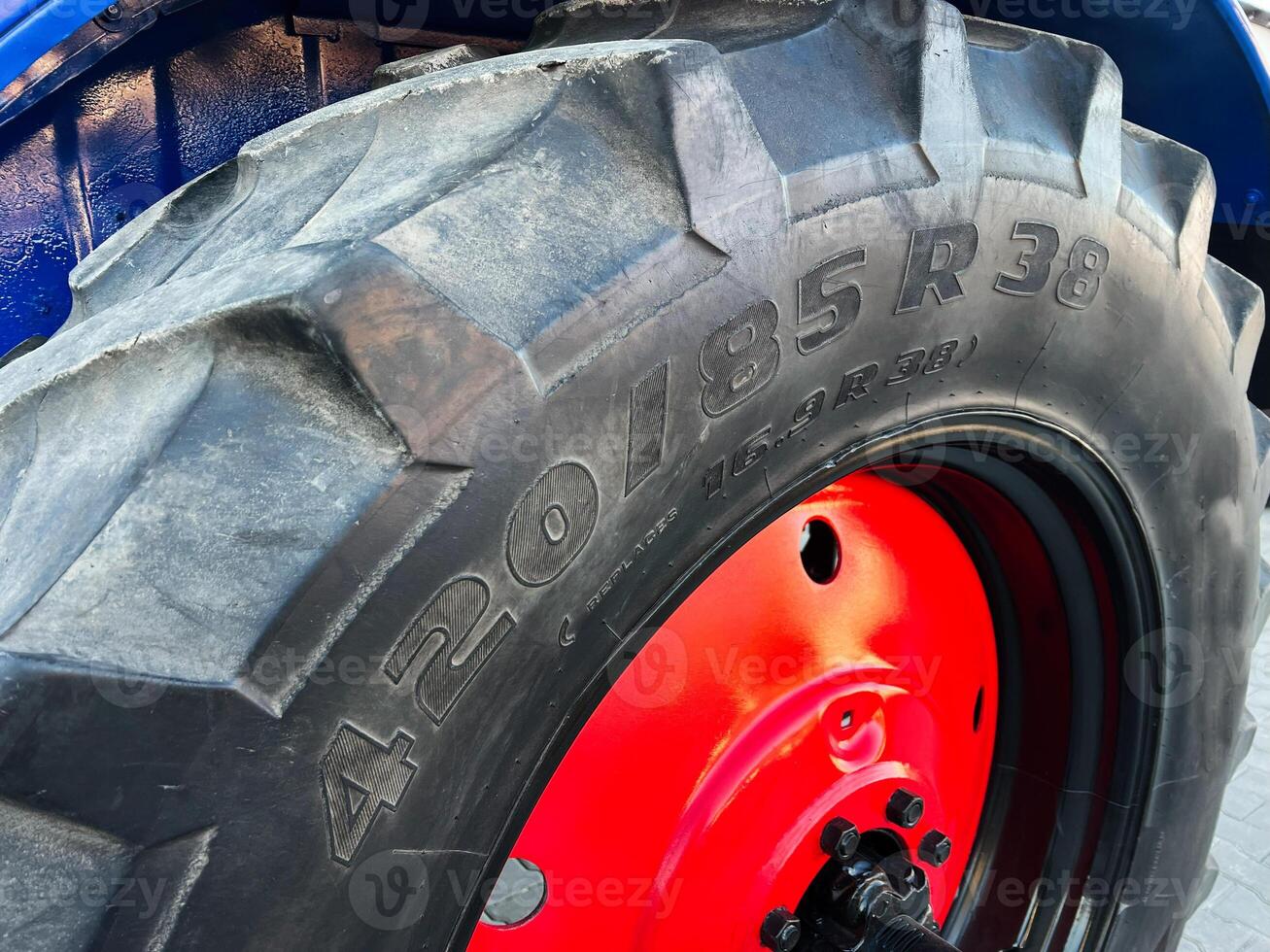 Large tractor wheel with red hub and detailed tire specifications photo