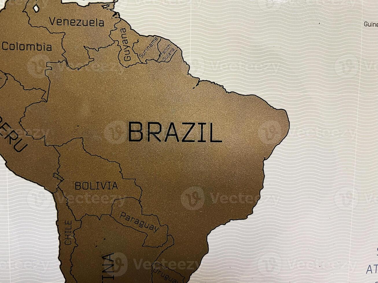 Gold map highlighting Brazil and surrounding South American countries on decorative background photo