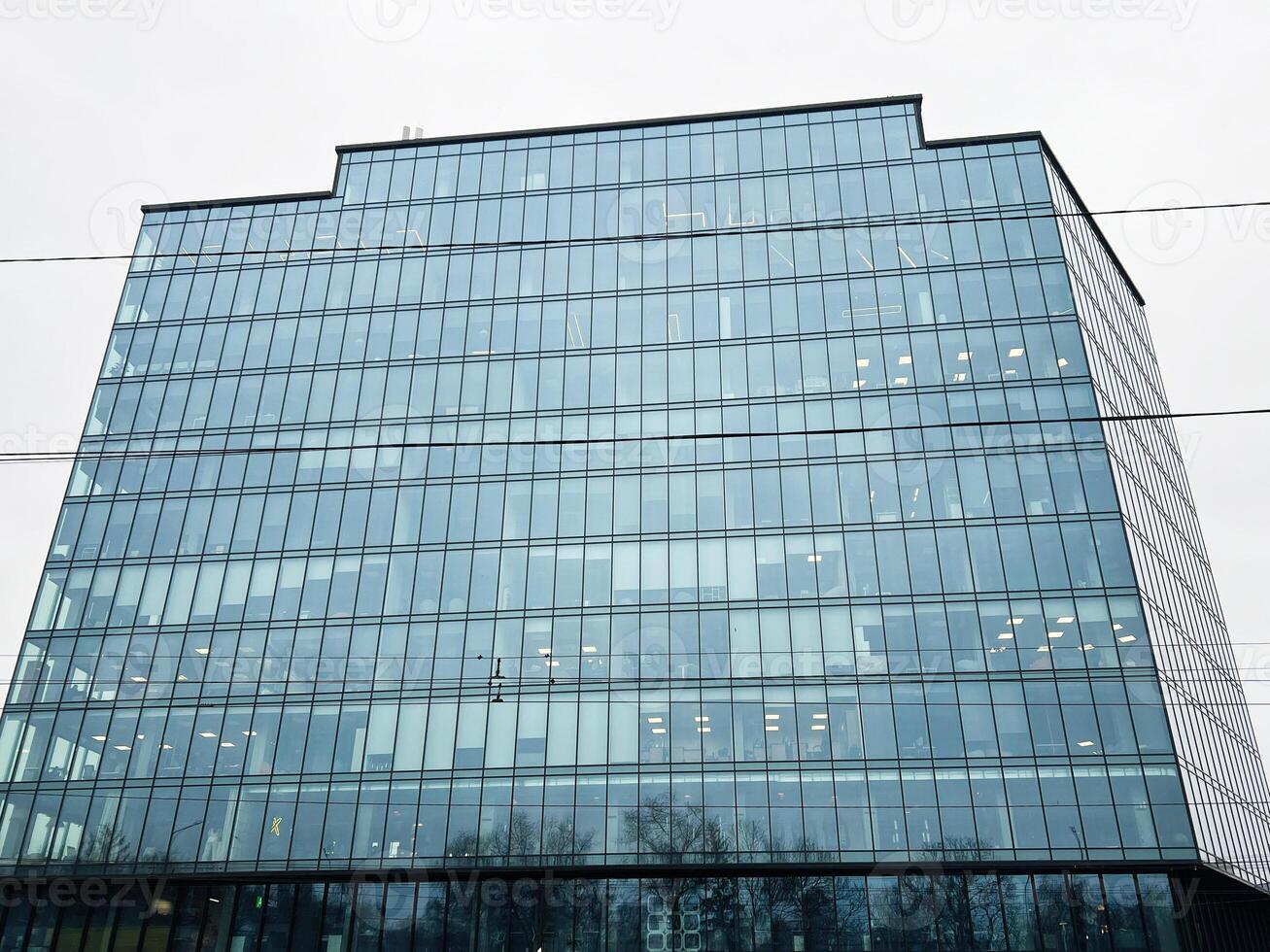 moderno vaso oficina edificio reflejando el nublado cielo y alrededores foto
