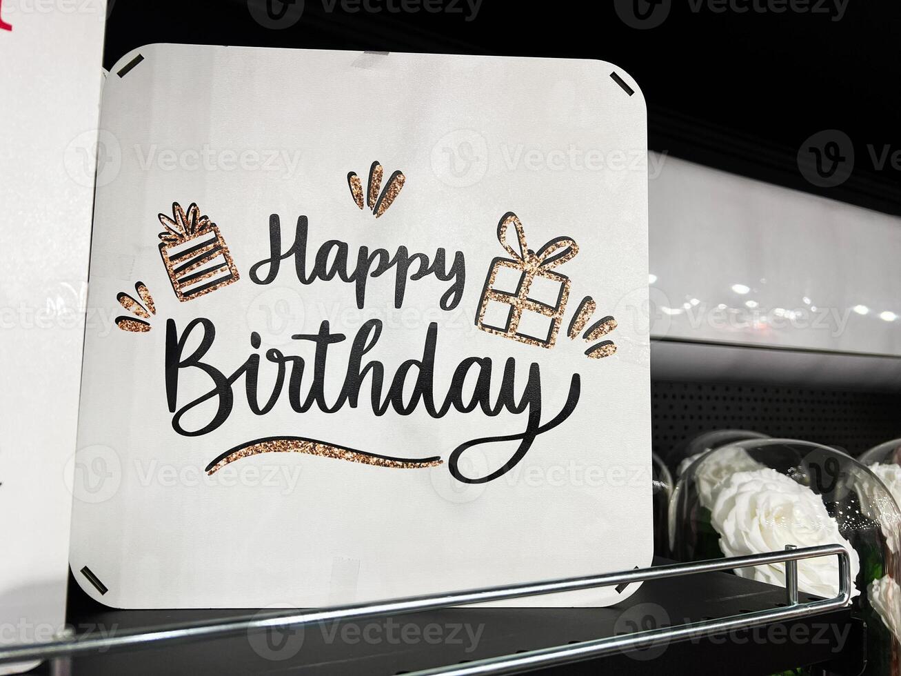 Decorative Happy Birthday sign with glitter design on store shelf photo