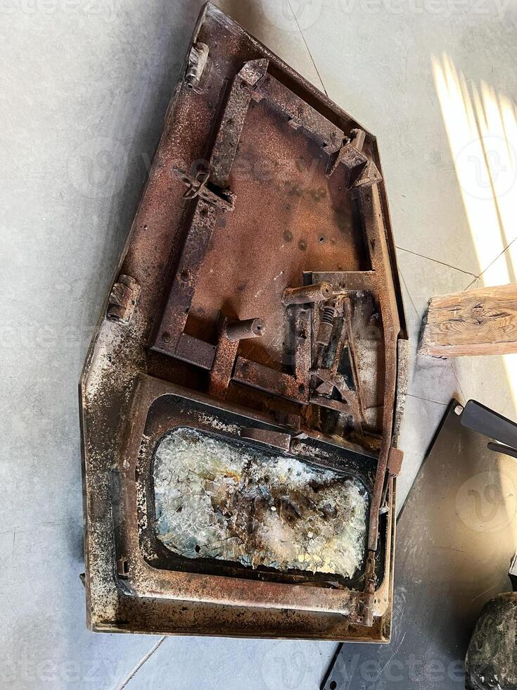 Rusty door with cracked glass showcasing aged and broken automotive components photo