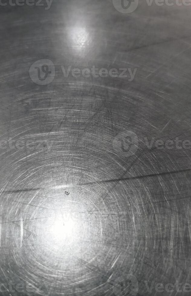 close up view of scratched metal surface, showcasing its texture and reflections photo