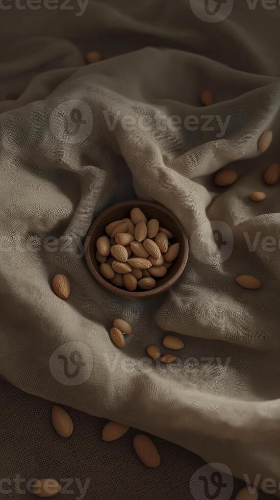 serene photograph of wooden bowl filled with almonds on textured fabric. soft, muted colors create calming atmosphere photo