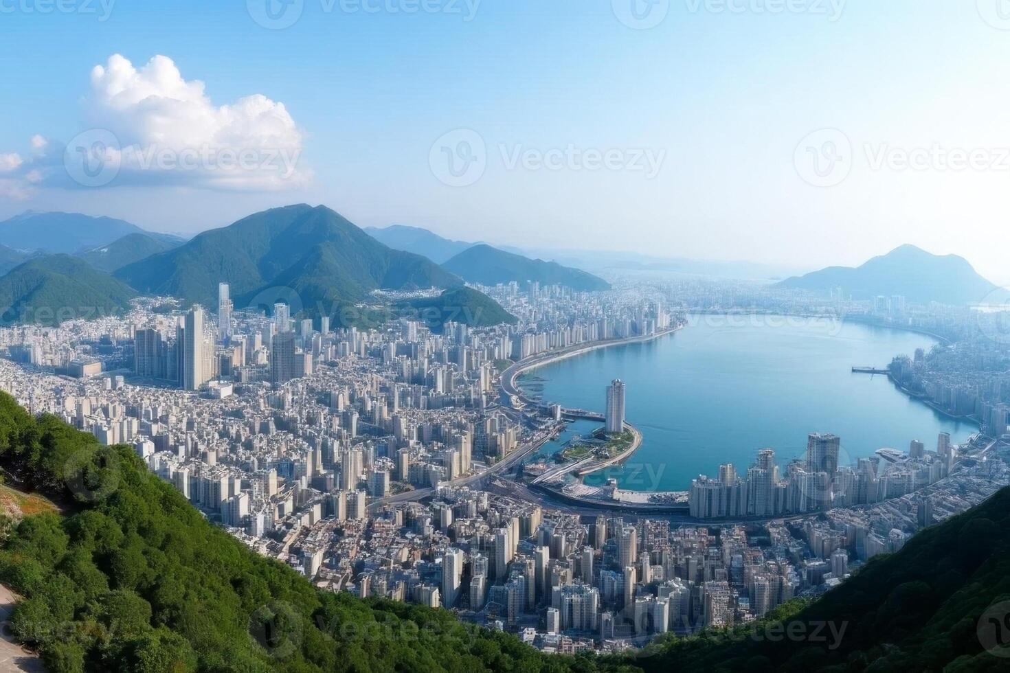 Panoramic View of Coastal City Skyline Surrounded by Lush Green Mountains and a Calm Bay photo