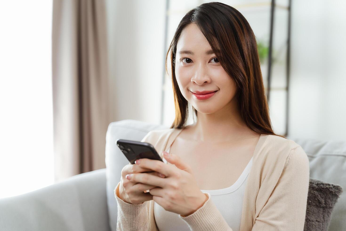 Beautiful woman holding and using a smartphone, using social media, shopping online photo