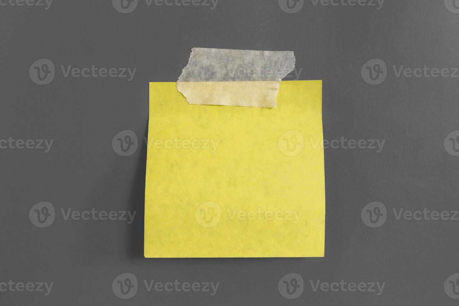 Blank yellow sticky notes with tape on a gray background photo