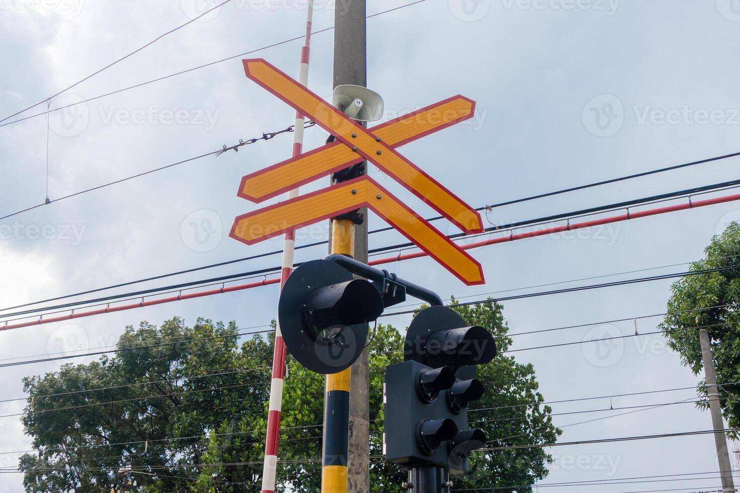 Railroad crossing sign with loudspeaker and signal lights photo
