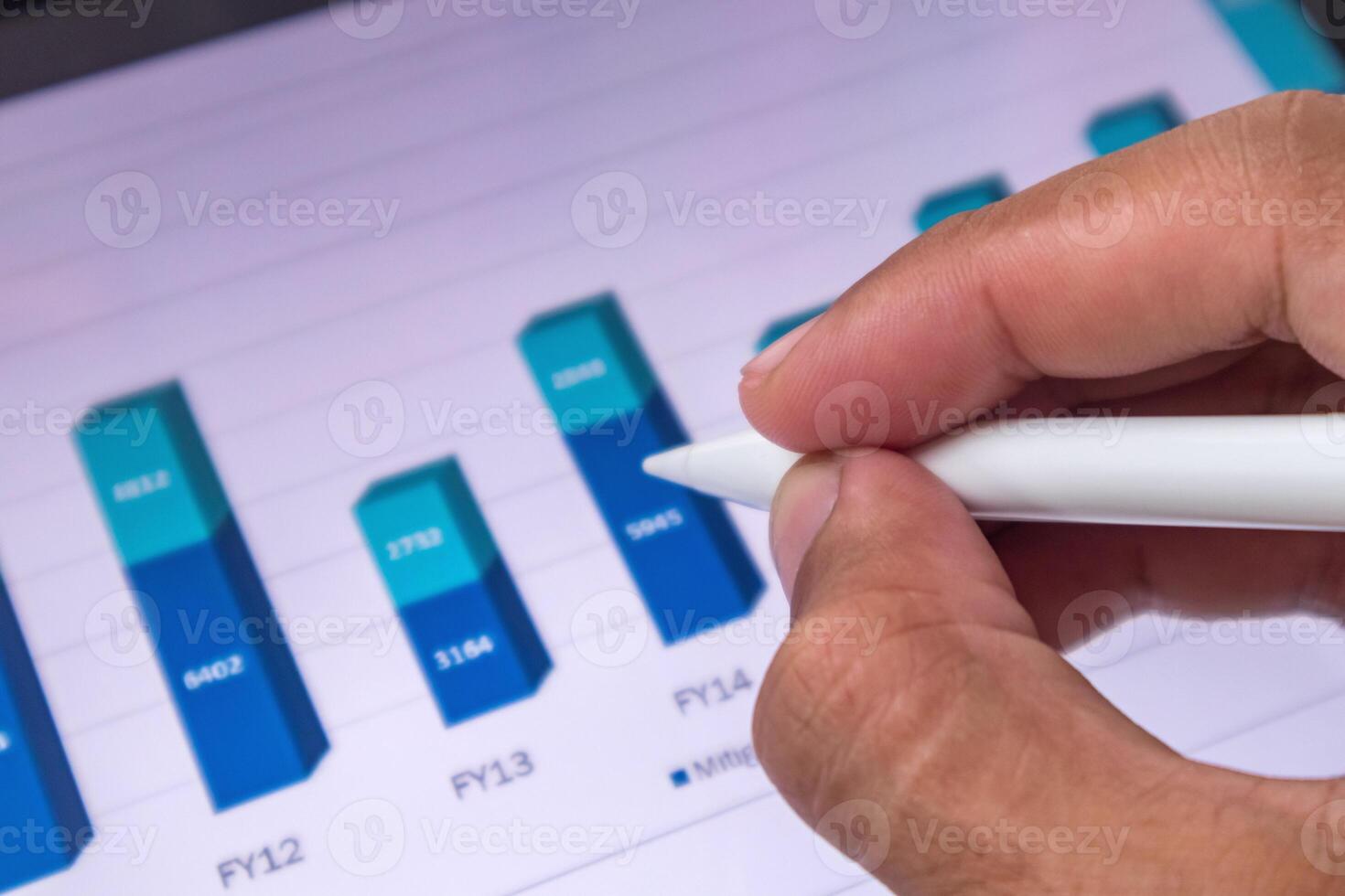 Analyst pointing to a growth chart of business financial data on digital screen photo