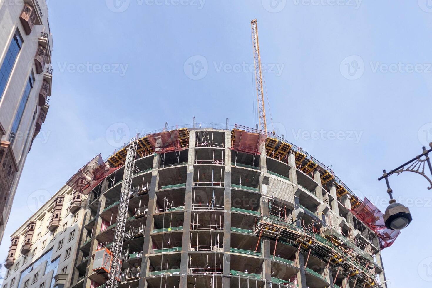 View of a building under construction with a crane on top photo