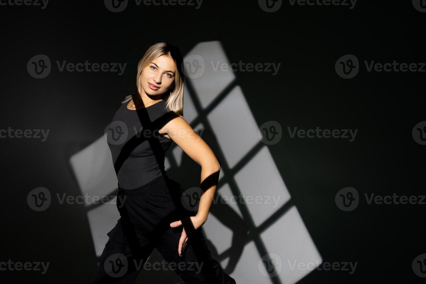 Young dancer performing with window-shaped shades on background. photo