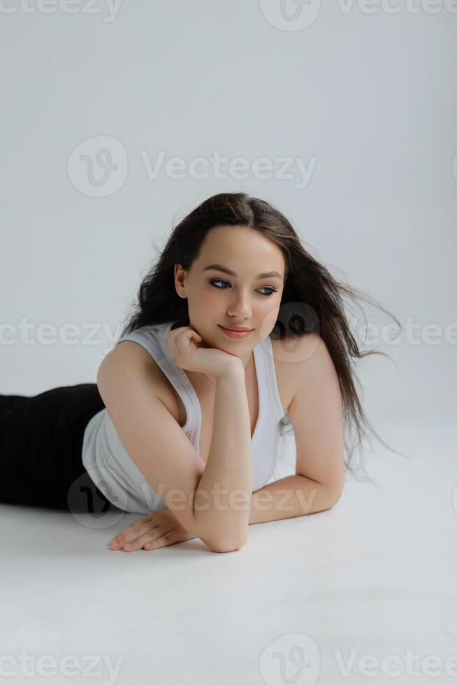 Girl lying on the floor smiling and wearing casual clothes photo