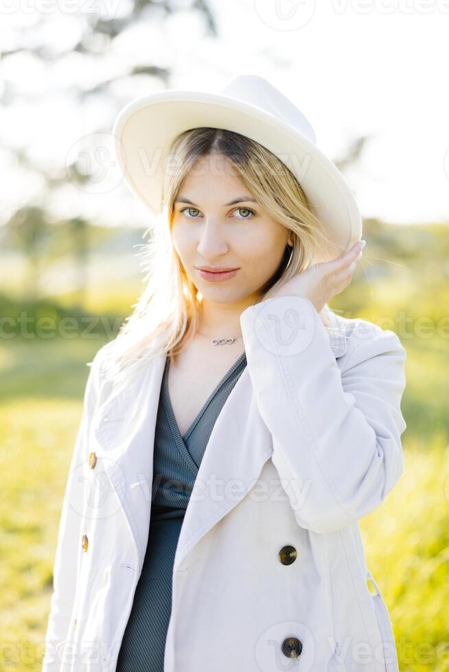 Beautiful pregnant woman in dress walking in the forest. Woman expecting baby born photo