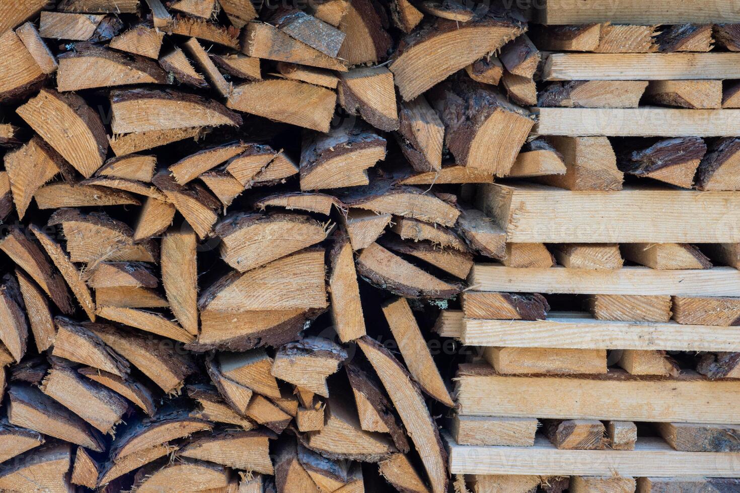 A stack of chopped firewood and logs arranged in neat rows for drying and storage. photo
