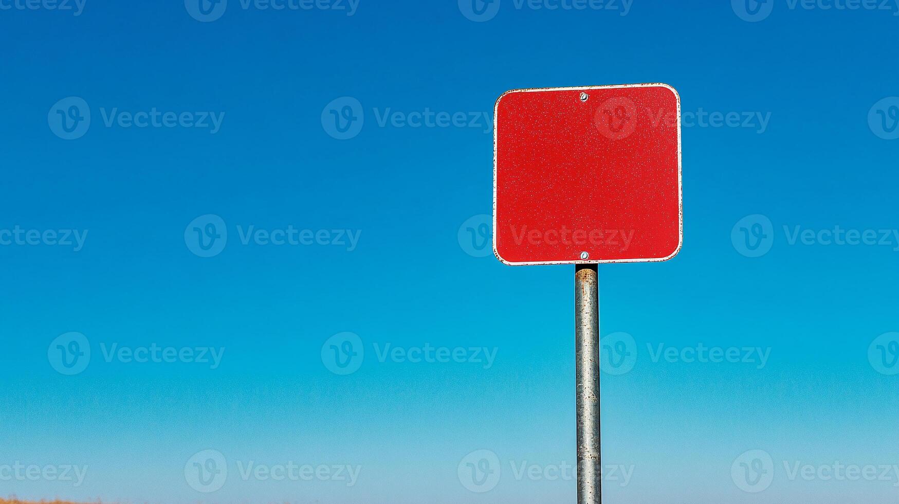 A red traffic sign on a pole in a field photo