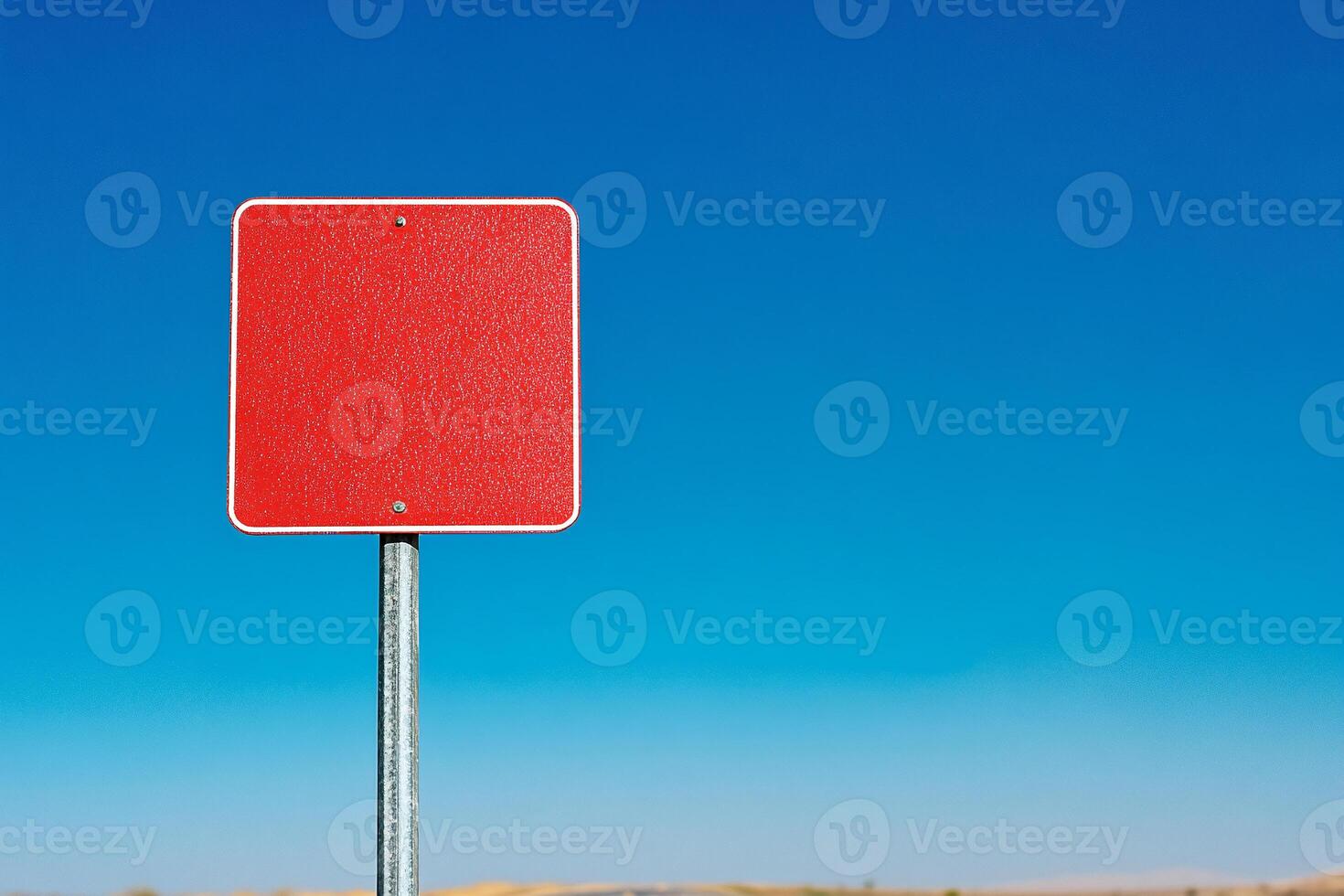 A red traffic sign on a pole in the middle of a desert photo