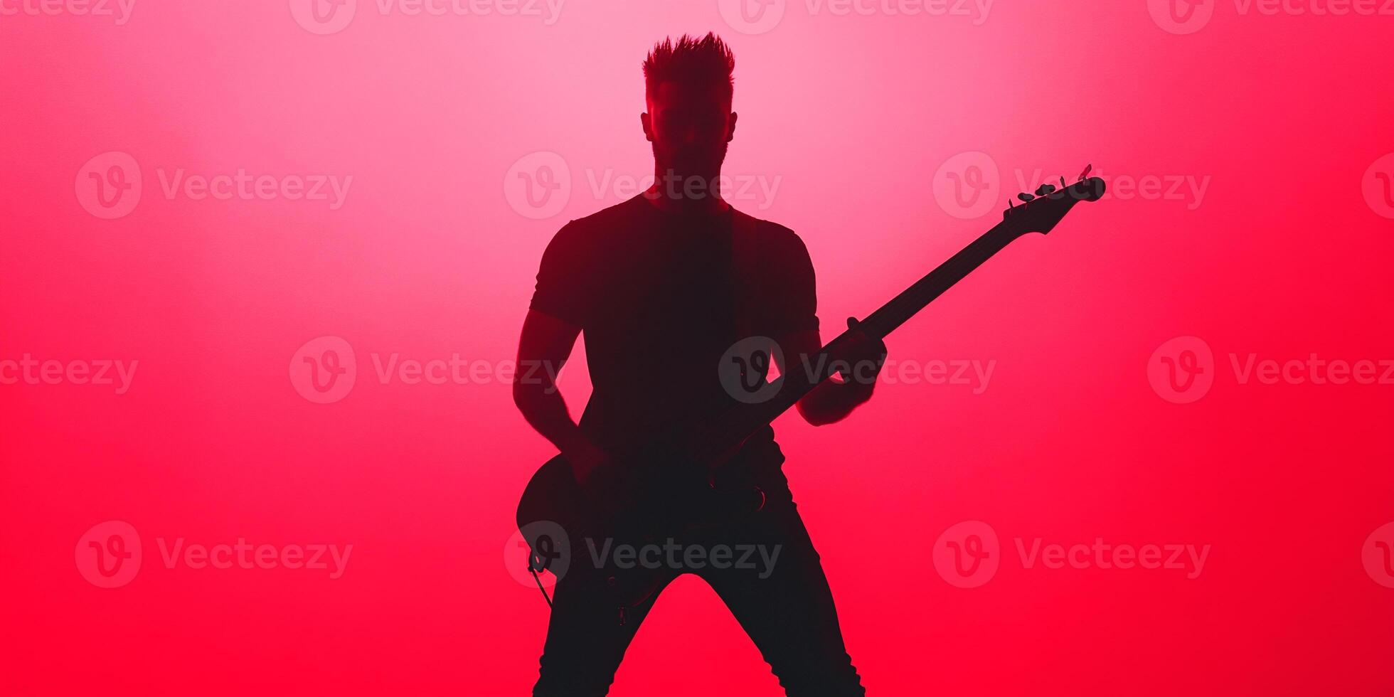 A silhouette of a man playing an electric guitar photo