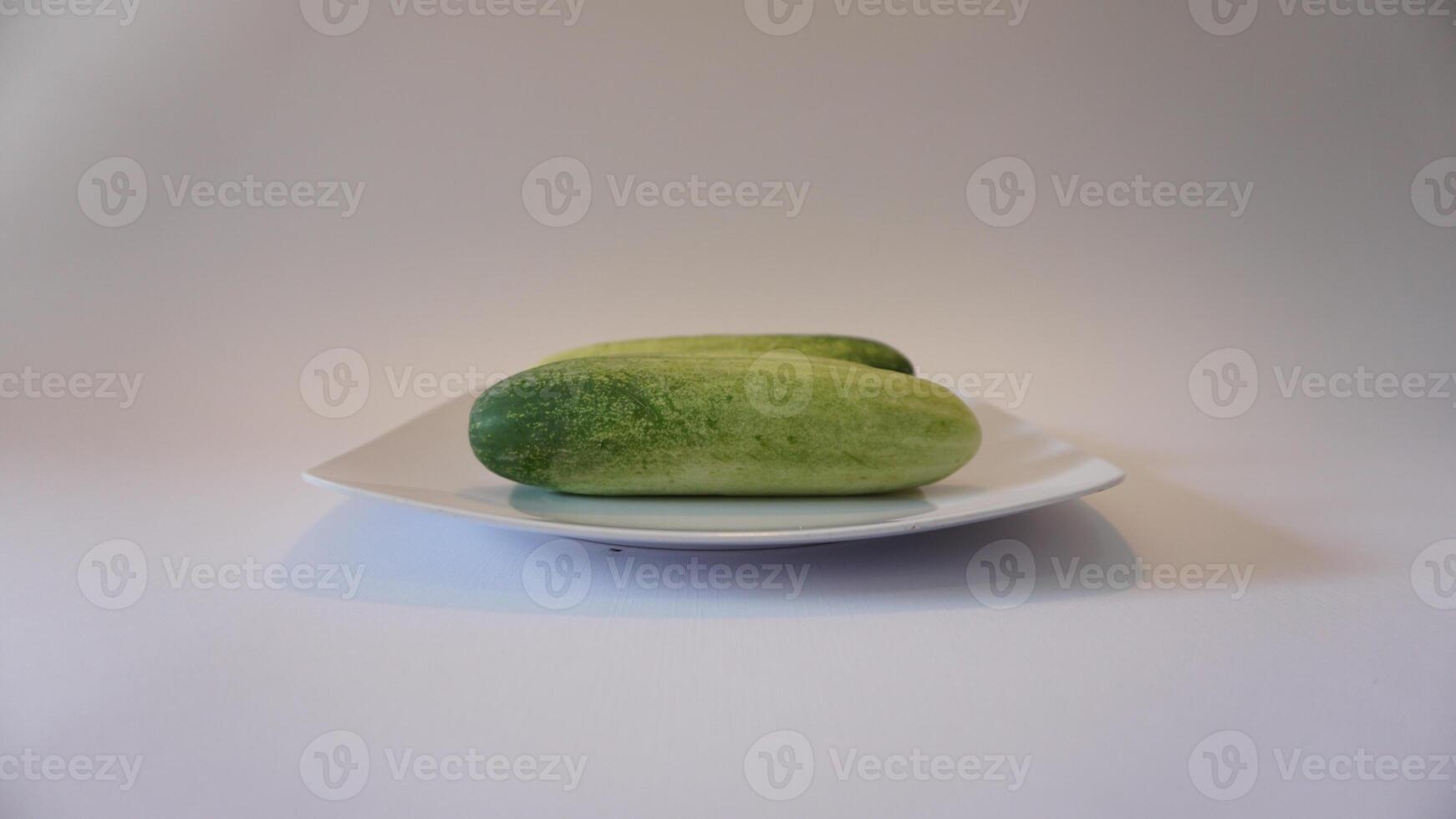 Two cucumbers on a white plate photo