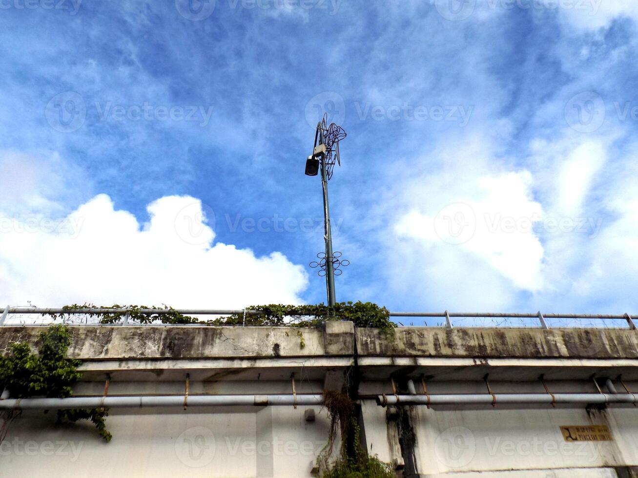 A cell phone tower on top of a concrete wall photo