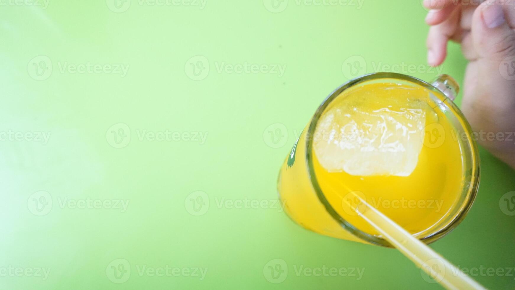 A person holding a glass of orange juice photo