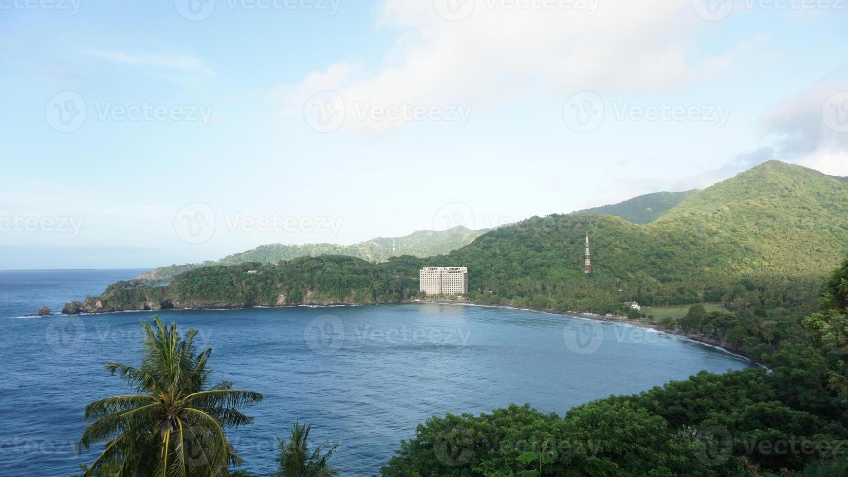 A view of the ocean and mountains from a hill photo