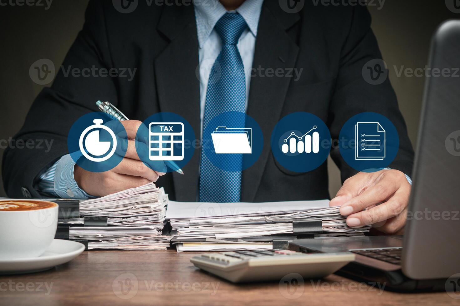 Businessman in a suit filing tax forms while sitting at the table photo