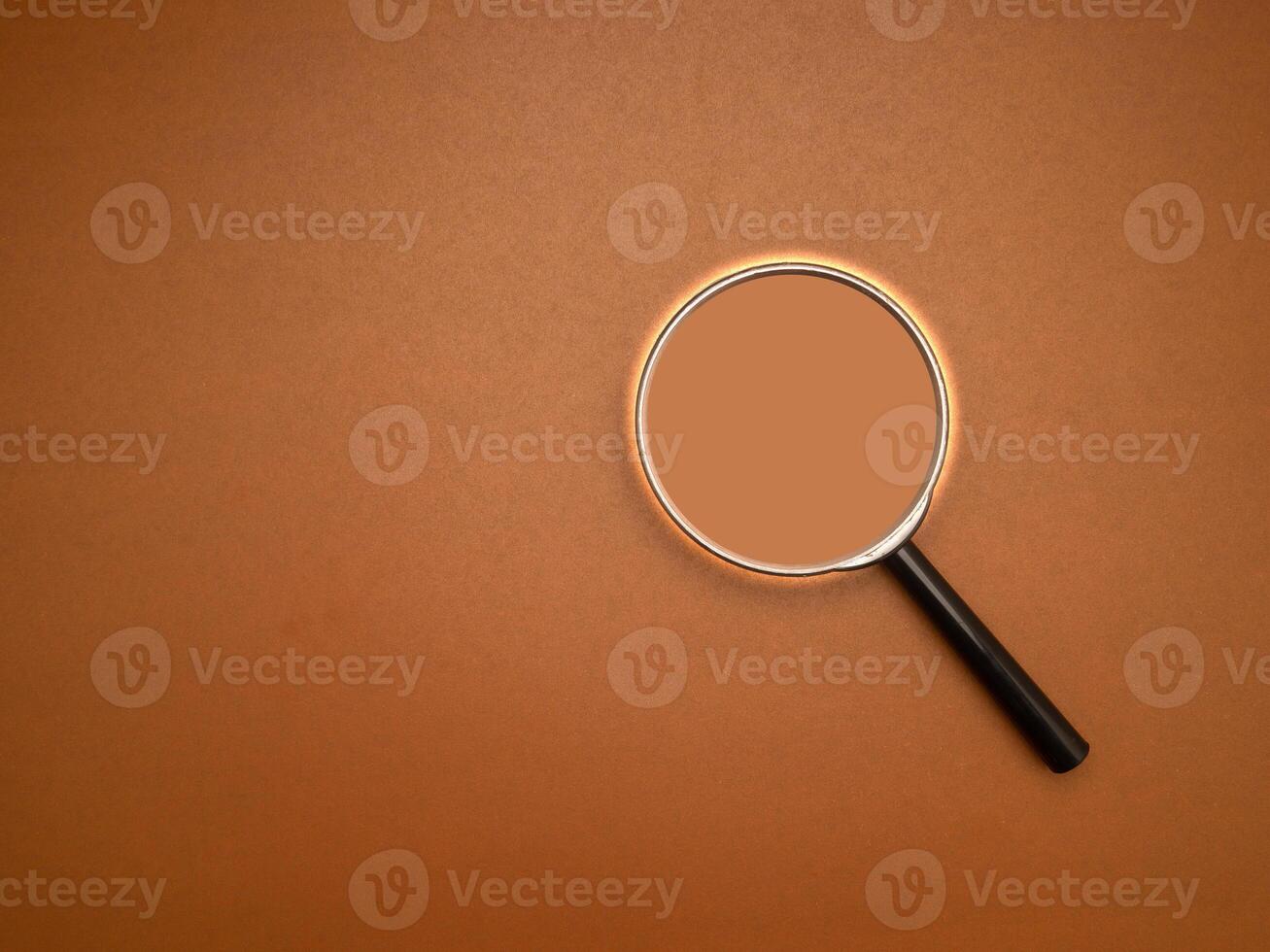 Top view of a magnifying glass on a brown background photo