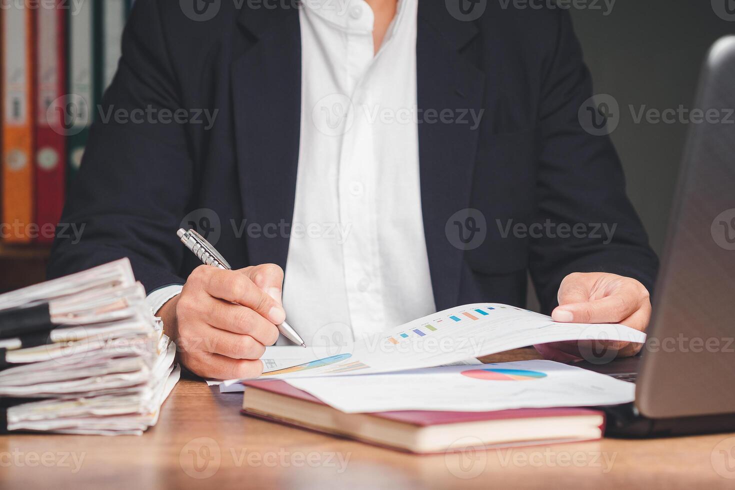 Businessman in a suit signing a lease contract or agreement while sitting at the table in the office photo