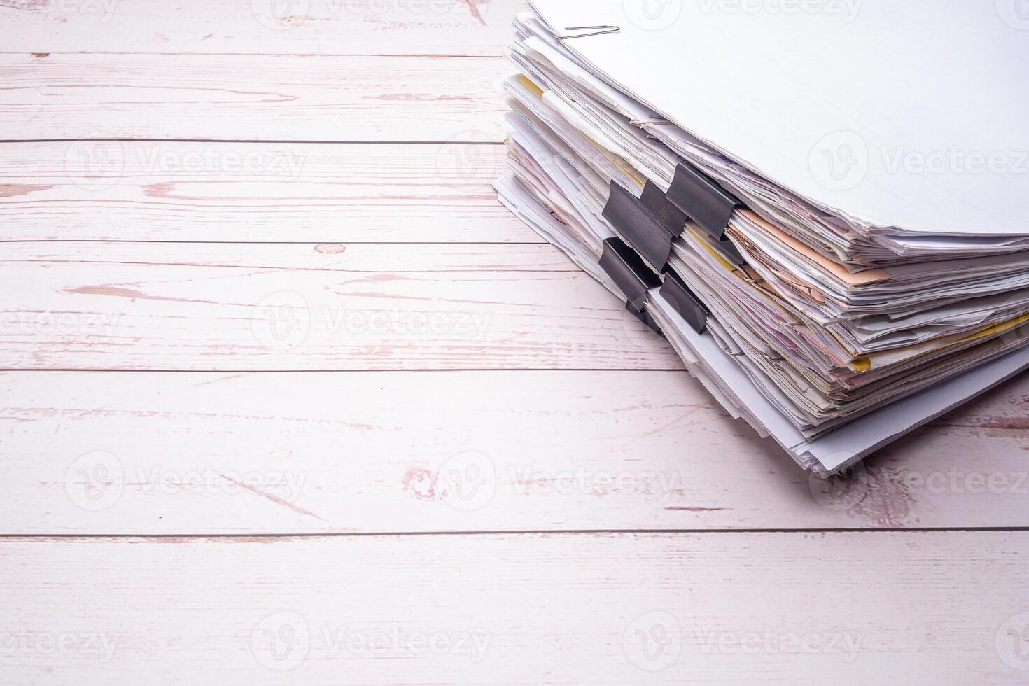 Stack of documents with binder clips on a white wooden table photo